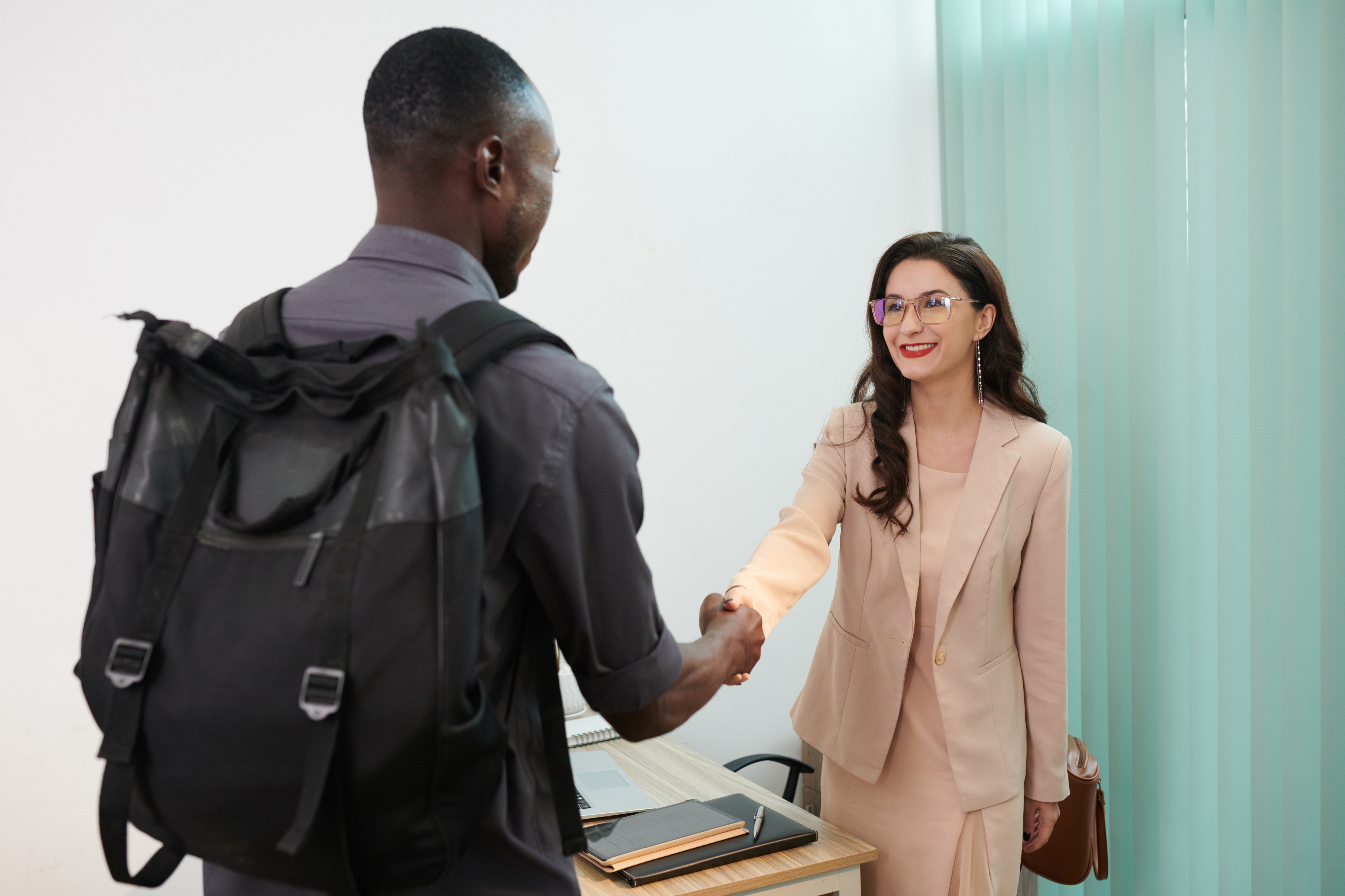 A job applicant shaking hands with a hiring manager before an interview.