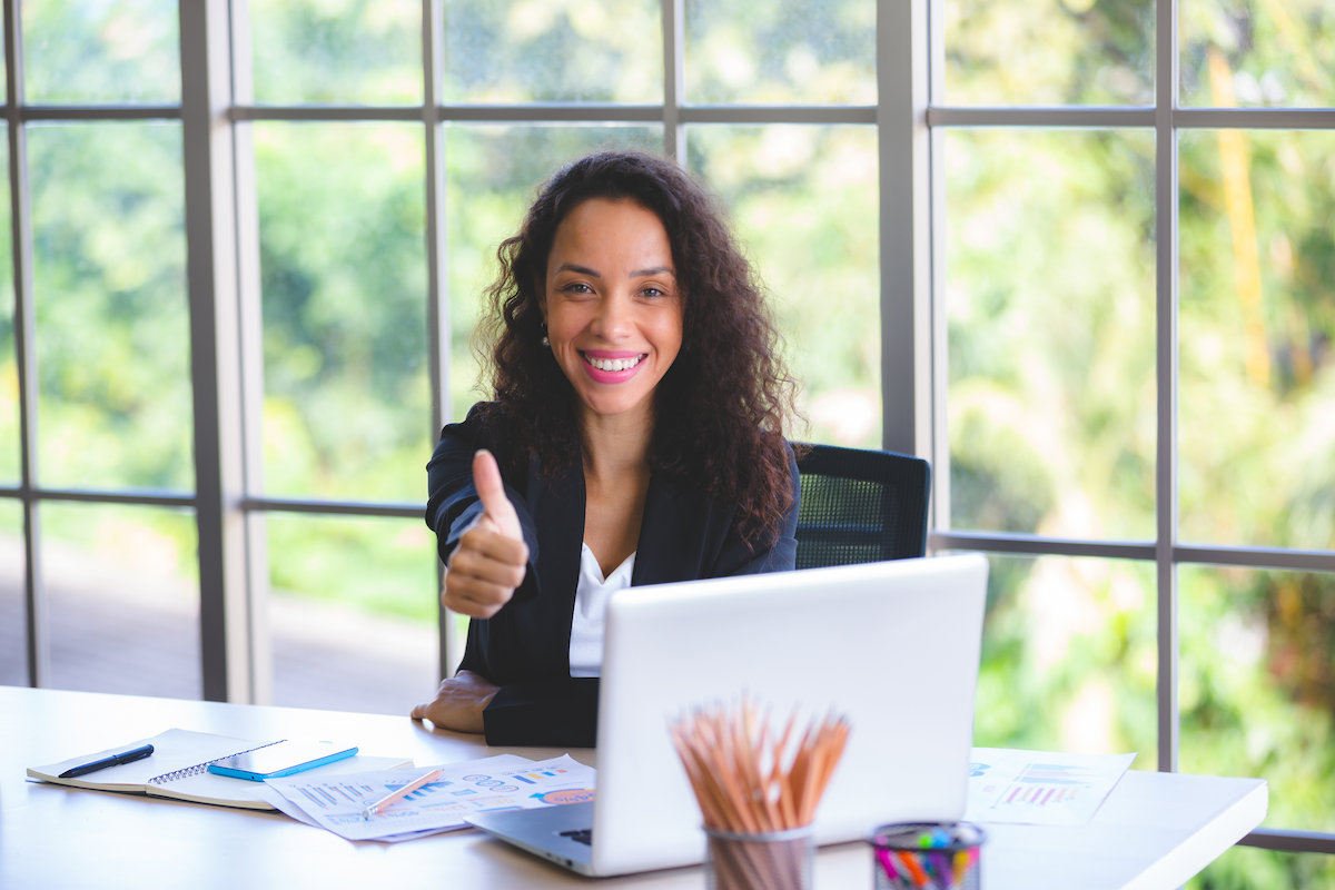 A smiling young professional giving a thumbs up